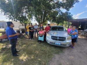 A group of people standing next to a car AI-generated content may be incorrect.