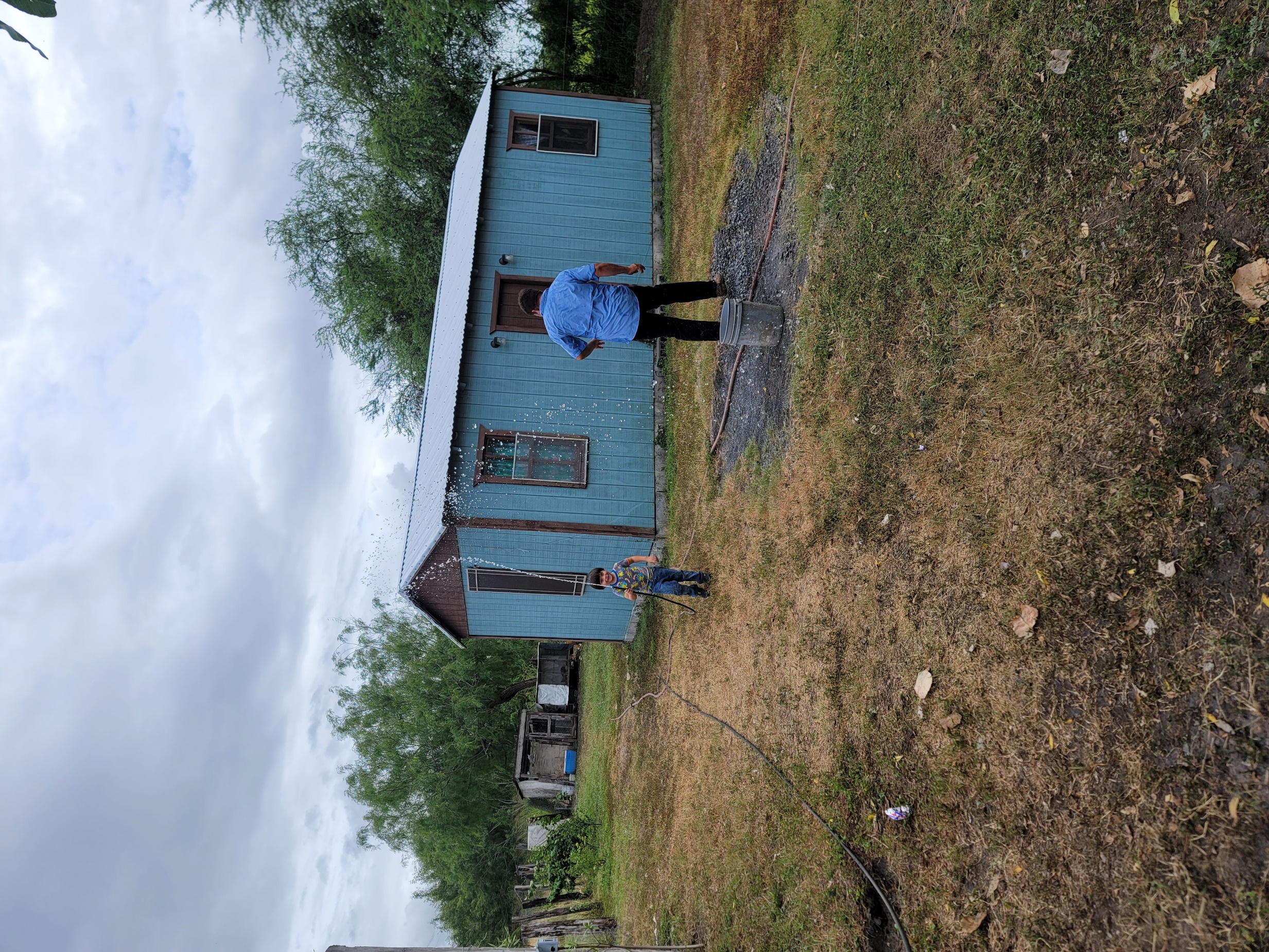 A person and child standing in front of a blue house
AI-generated content may be incorrect.