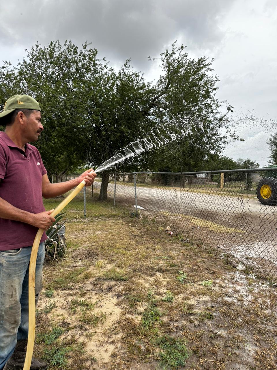 A person watering a yard with a hose
AI-generated content may be incorrect.