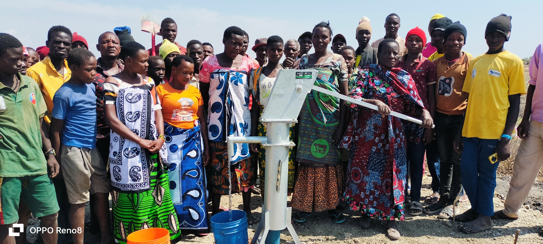 A group of people standing next to a water pump

AI-generated content may be incorrect.