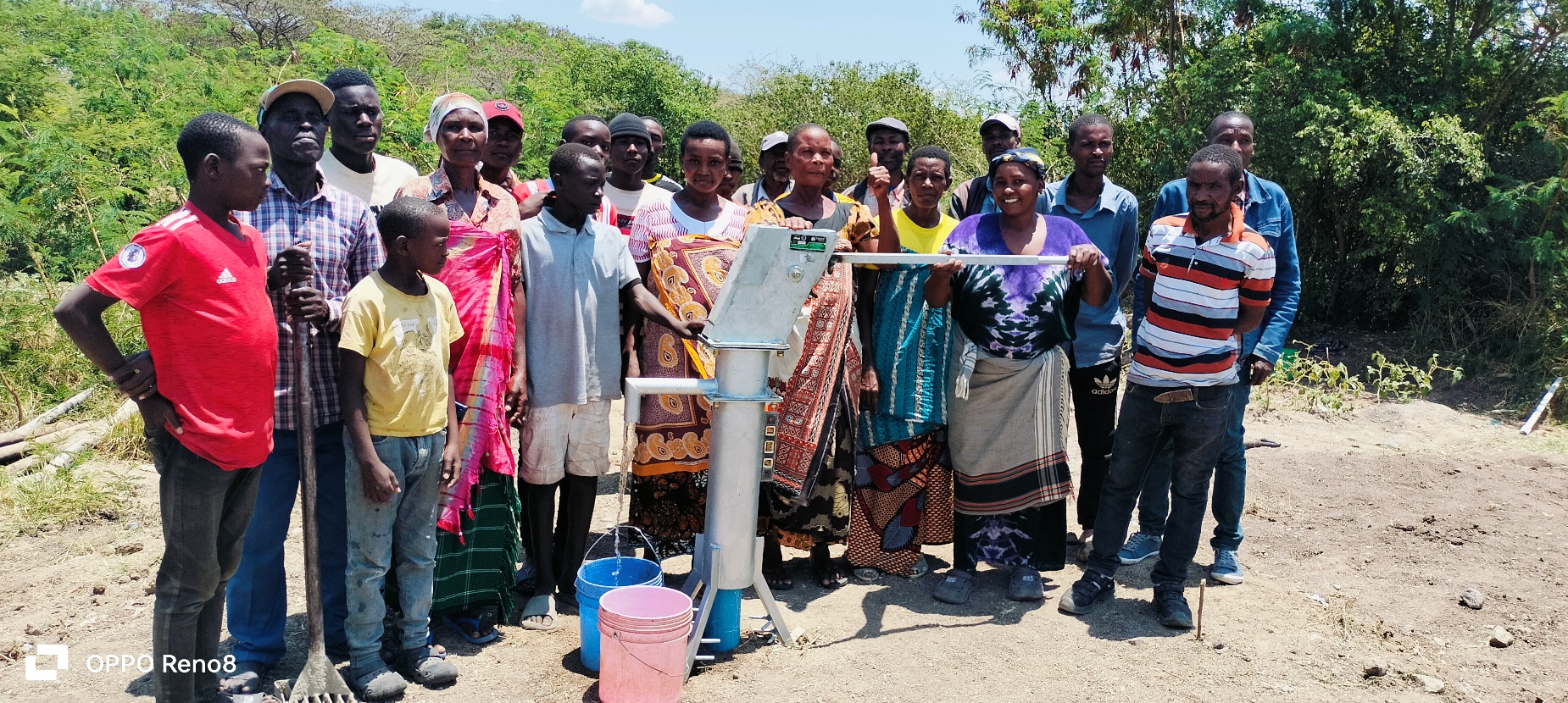 A group of people standing next to a water pump
AI-generated content may be incorrect.